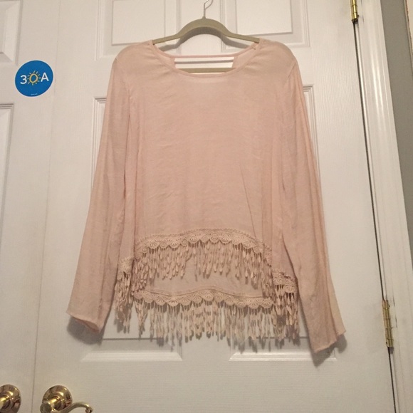 ivory long sleeve top with fringe at bottom.