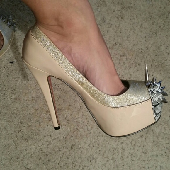 Spiked nude heels with red bottoms.