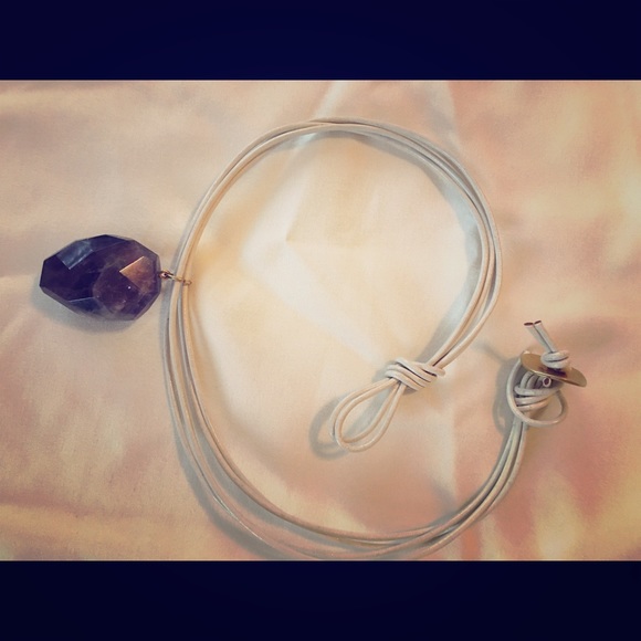 Necklace with purple jewel.