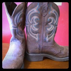 Brown Ariat boots with design.
