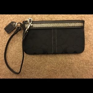 Black coach wristlet with beading embellishment.