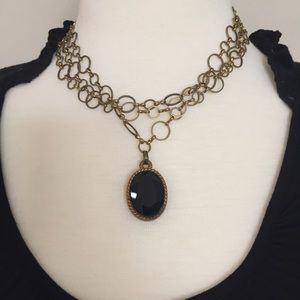 Three chained necklace with black stone pendant.