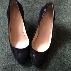Black snakeskin pumps