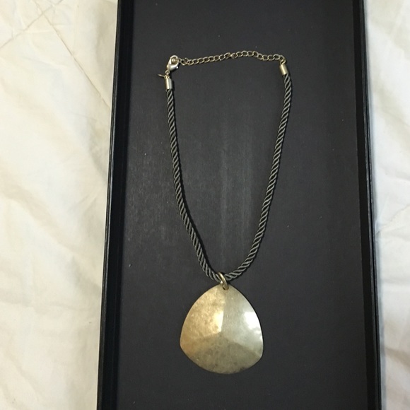 Gold medallion necklace on green rope