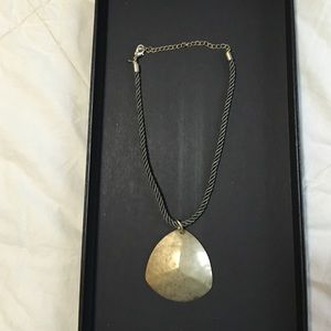 Gold medallion necklace on green rope