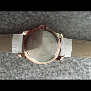 It's a rose gold watch with a white band