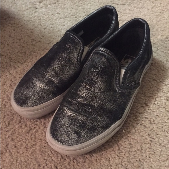 Black and metallic silver Vans slip ons