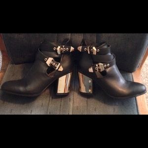 Black boots with gold metal accents by JustFab