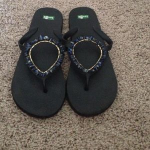 Blue lapis gold and black Sanuk flip flops