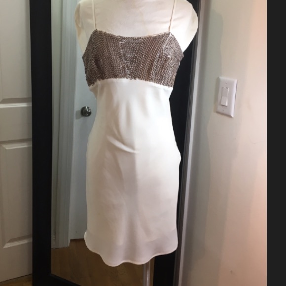 Cream dress with chain detail on bust.