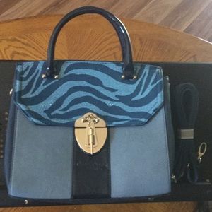 Blue handbag with handles and a strap.