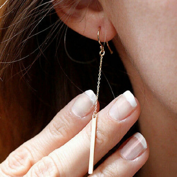 Gold vertical stick chain earrings.