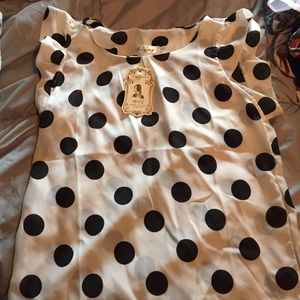 White shirt w black polka dots. Ruffle sleeves.