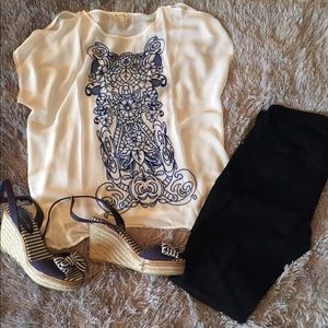 Sheer white blouse with blue lace design.