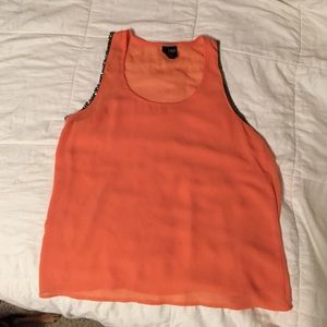 Tank top. Coral color, with decal on sleeves.