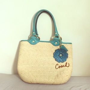 Straw coach handbag with flower detail.