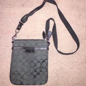 A dark green coach crossbody bag.
