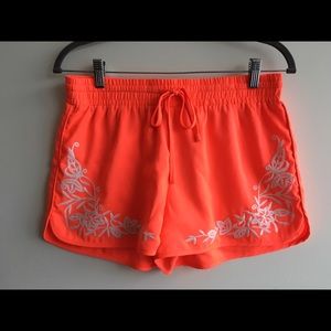 Bright coral shorts with floral embroidery