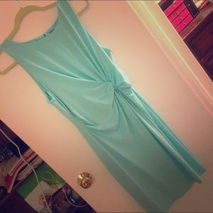 Turquoise sleeveless dress with open back.