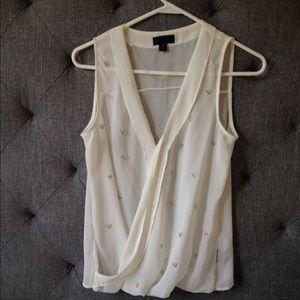 Sleeveless white dress top with gold accents