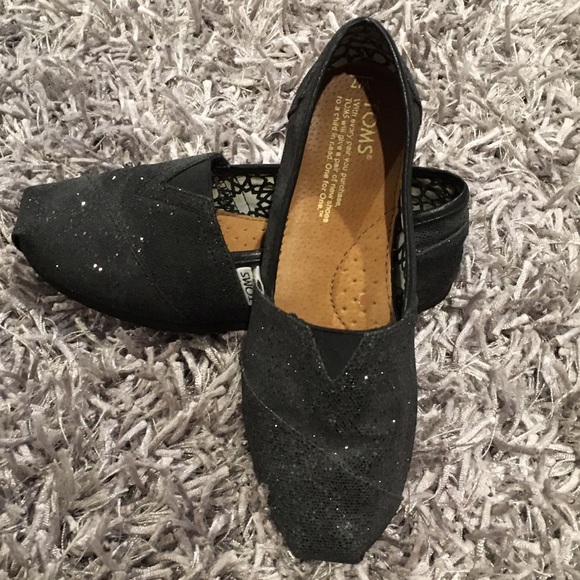 Toms classic black glitter slip ons.