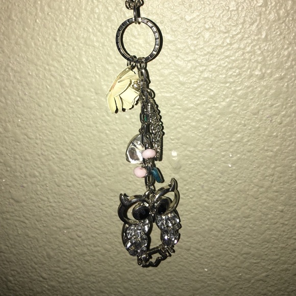 long necklace. owl emblem.