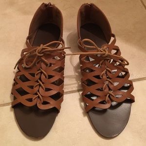 Tan, low gladiator sandals with zipper in the back