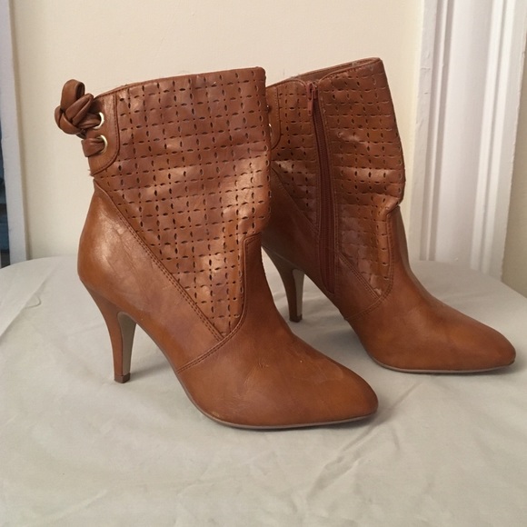 Brown heeled boots, rise above ankle.