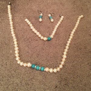 A pearl necklace set with a bracelet and earrings
