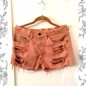 Distressed pink high-waisted Levi's shorts.