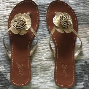 Carlos Santana gold flower flip flops