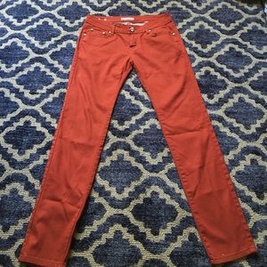 Red/burnt orange skinny jeans.