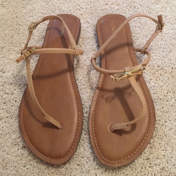 Flat beige sandals with gold bow detail
