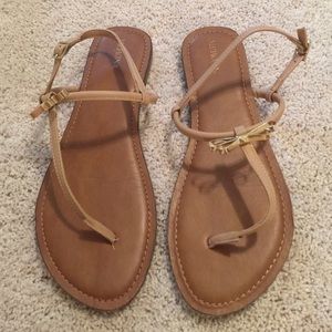 Flat beige sandals with gold bow detail