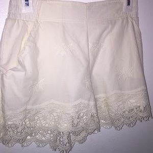 Cream colored shorts. Flower stitched designs.