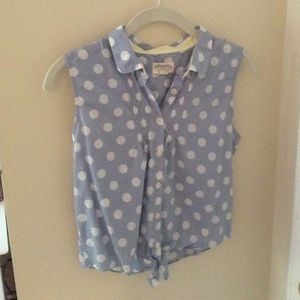 A sky blue, polka dot, button down, sleeveless top