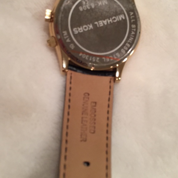 {Michael Kors} Gold tone black leather watch.