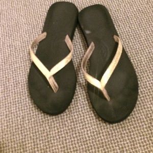 Gold and black flip flops