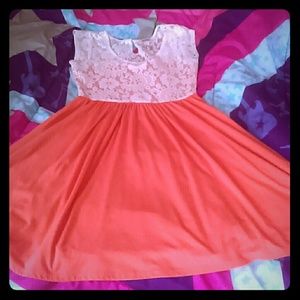 A peach color dress with white floral at the top