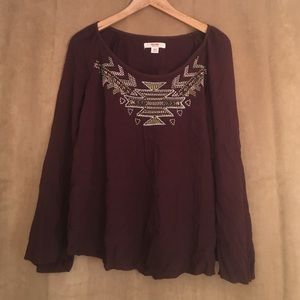 Long sleeve, maroon colored shirt with design.