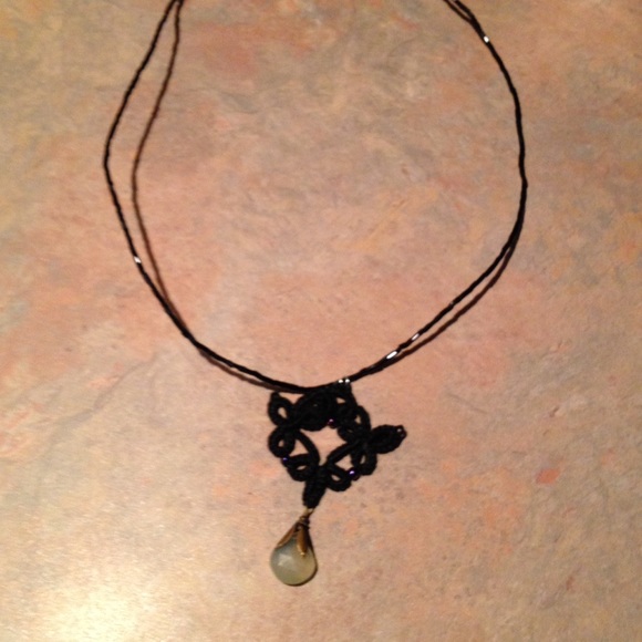 Black tatted pendant on black see bead necklace
