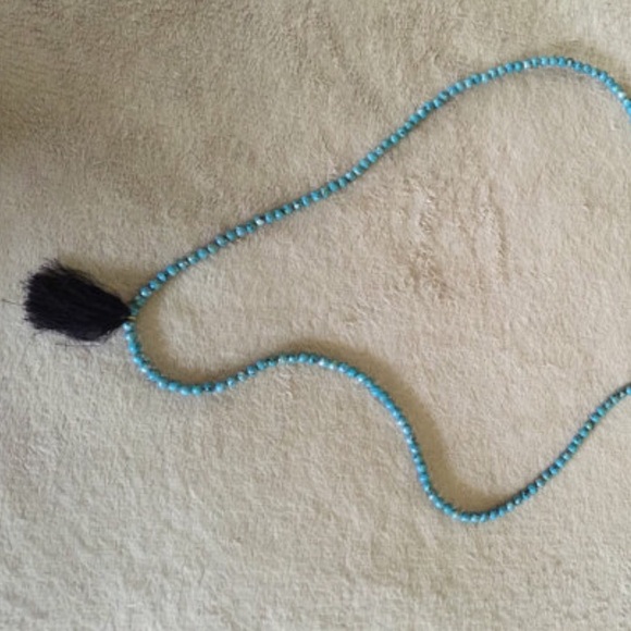 Turquoise beaded necklace with black tassel.