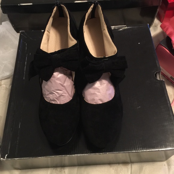 Black suede heels w/ zipper back and bow at ankle.