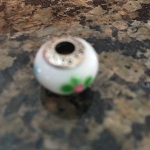 Green and pink flower on white bead