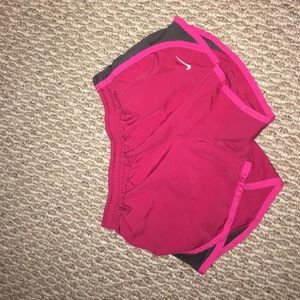 Red and Pink Nike shorts with black on the sides.