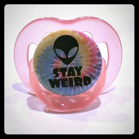 Orangey-pink "stay weird" pacifier