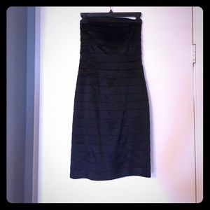 Bebe; Sleeveless black satin dress; form fitting.