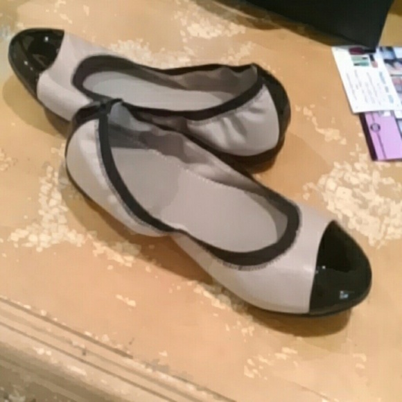 Tan ballet flats with black toe and heel.