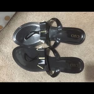 Black jelly flip flops. With gold bow accent
