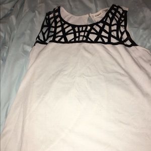 White tank with black crossing around the neck